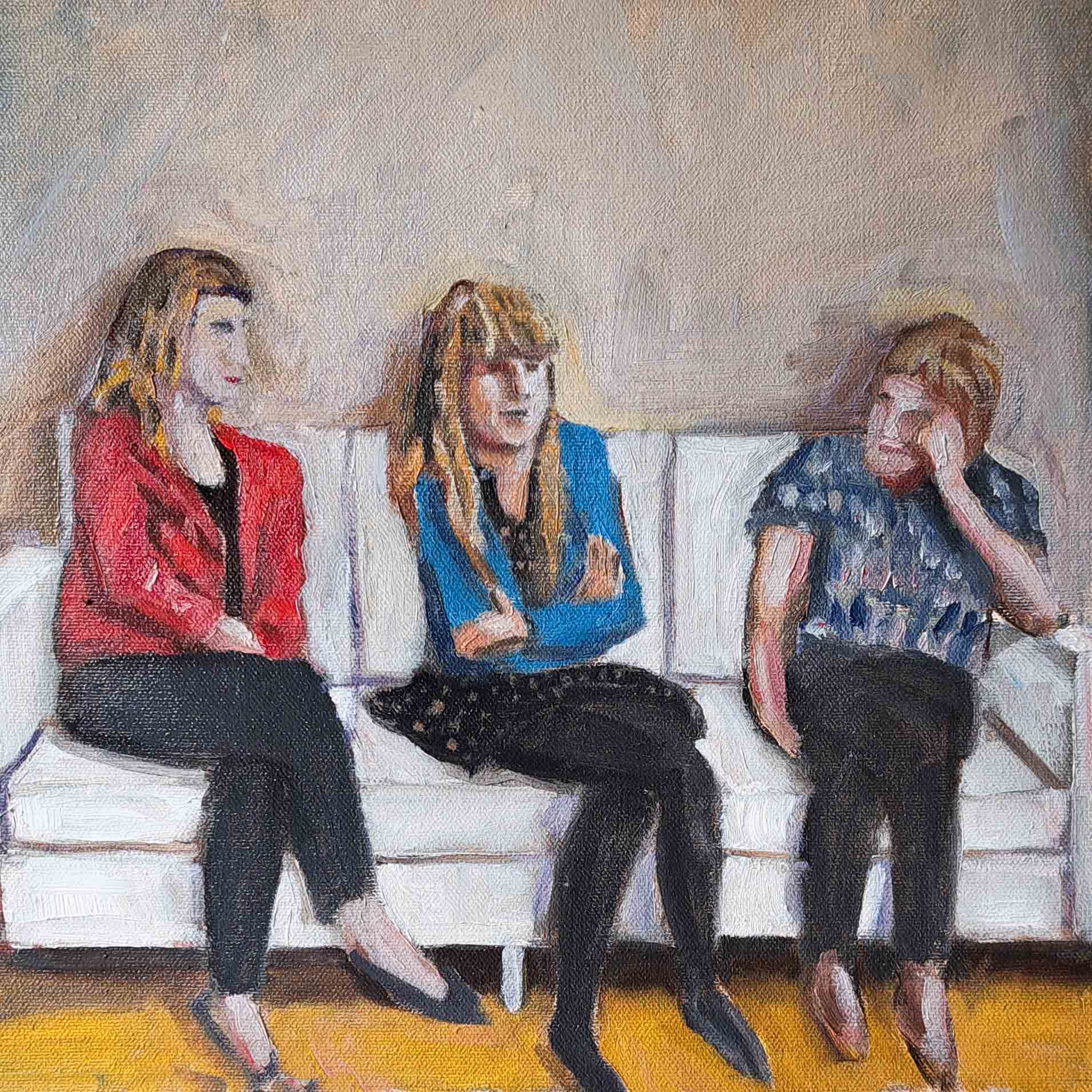 three people on a white sofa